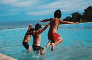 Drie jongens springen in het zwembad | Groen Rechts